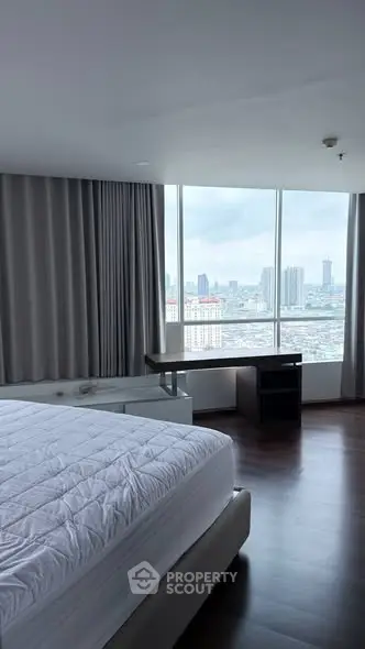 Spacious bedroom with panoramic city view and modern furnishings