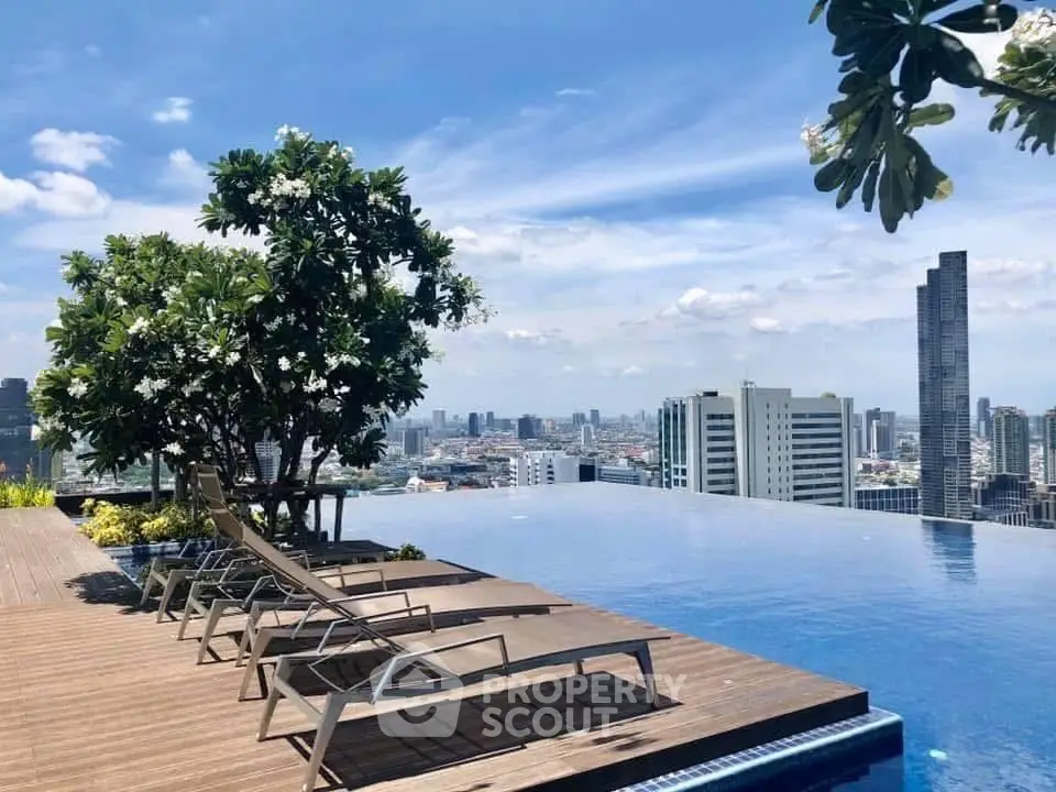 Stunning rooftop pool with panoramic city skyline view and lush greenery.