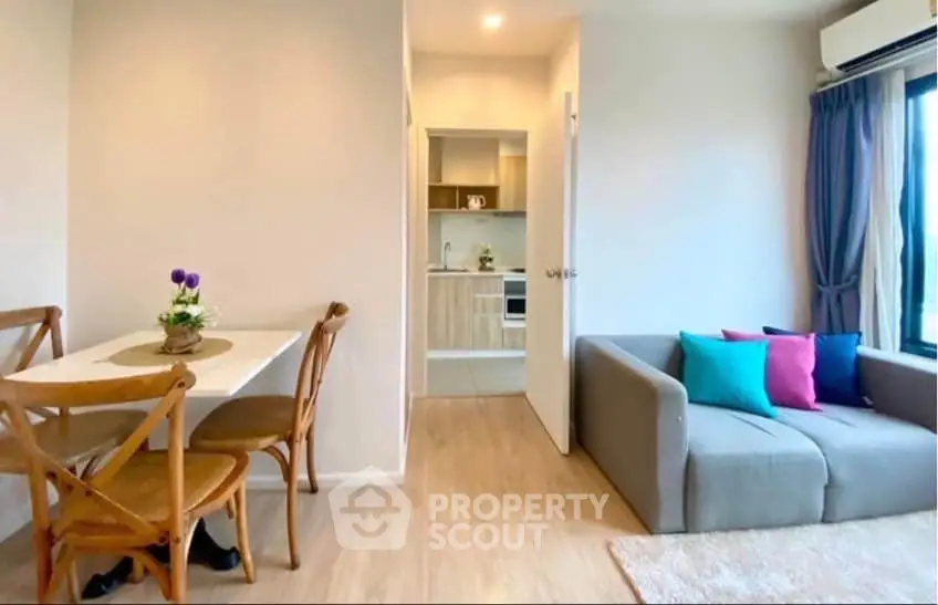 Modern living room with cozy sofa and dining area in open layout apartment.