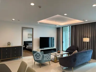 Luxurious modern living room with elegant furniture and large TV, leading to a cozy bedroom.