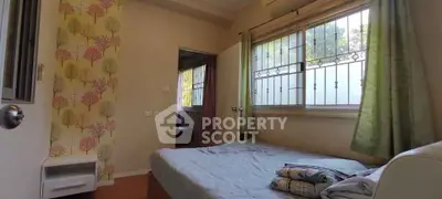 Cozy bedroom with large window and floral accent wall