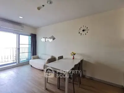 Modern living room with dining area and balcony access, featuring minimalist decor and natural light.