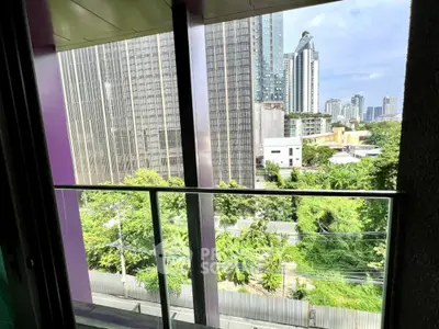 Modern urban balcony with cityscape view and lush greenery