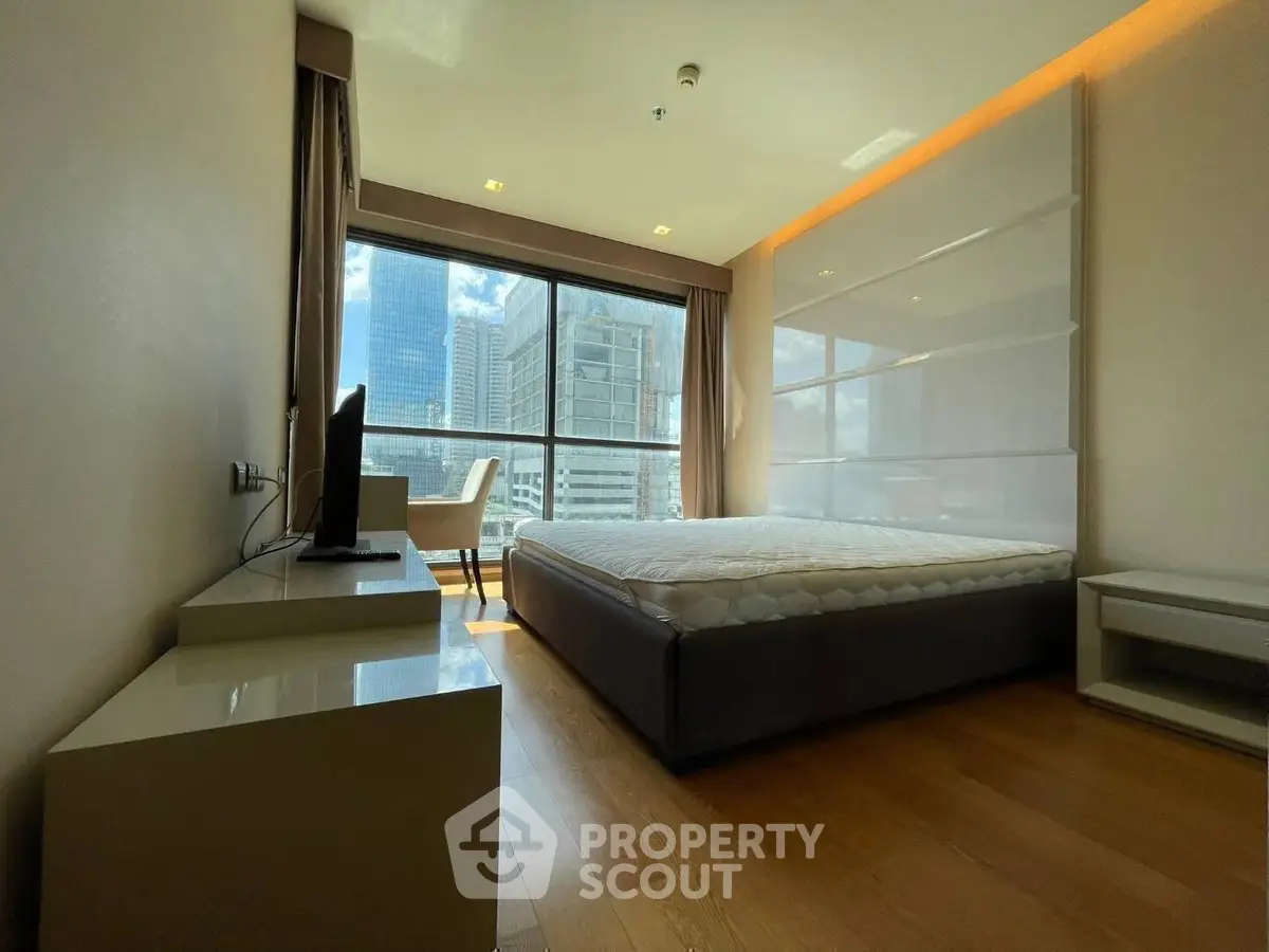 Modern bedroom with city view and sleek furnishings in high-rise apartment