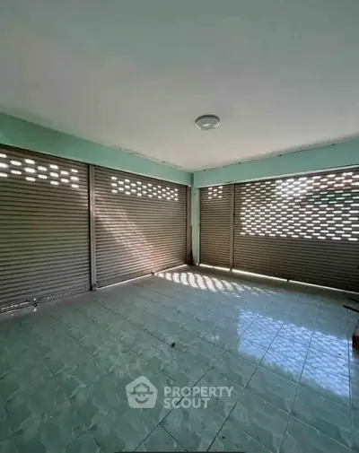 Spacious tiled room with large windows and ample natural light, perfect for versatile use.