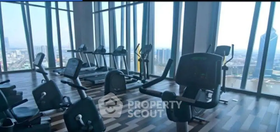 Spacious gym with panoramic city views and modern fitness equipment