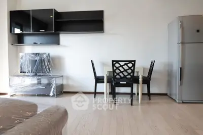 Modern living room with sleek furniture and stainless steel fridge, perfect for contemporary urban living.