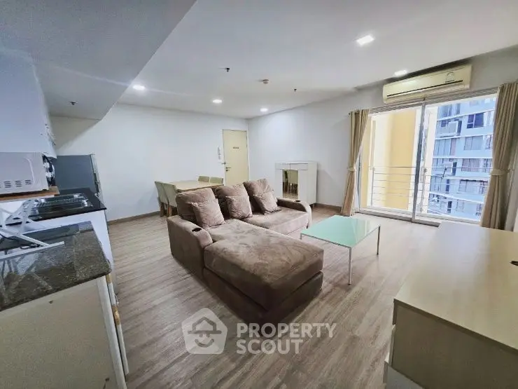 Spacious living room with modern furniture and balcony view in a stylish apartment.