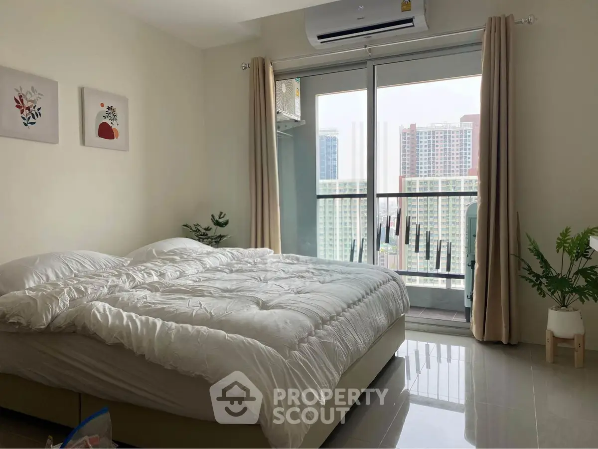 Bright and cozy bedroom with large windows and city view, perfect for urban living.