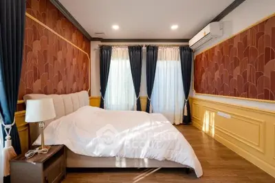 Luxurious bedroom with elegant decor and natural light, featuring stylish curtains and modern air conditioning.