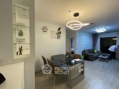 Modern open-plan living and dining area with stylish lighting and contemporary furniture.