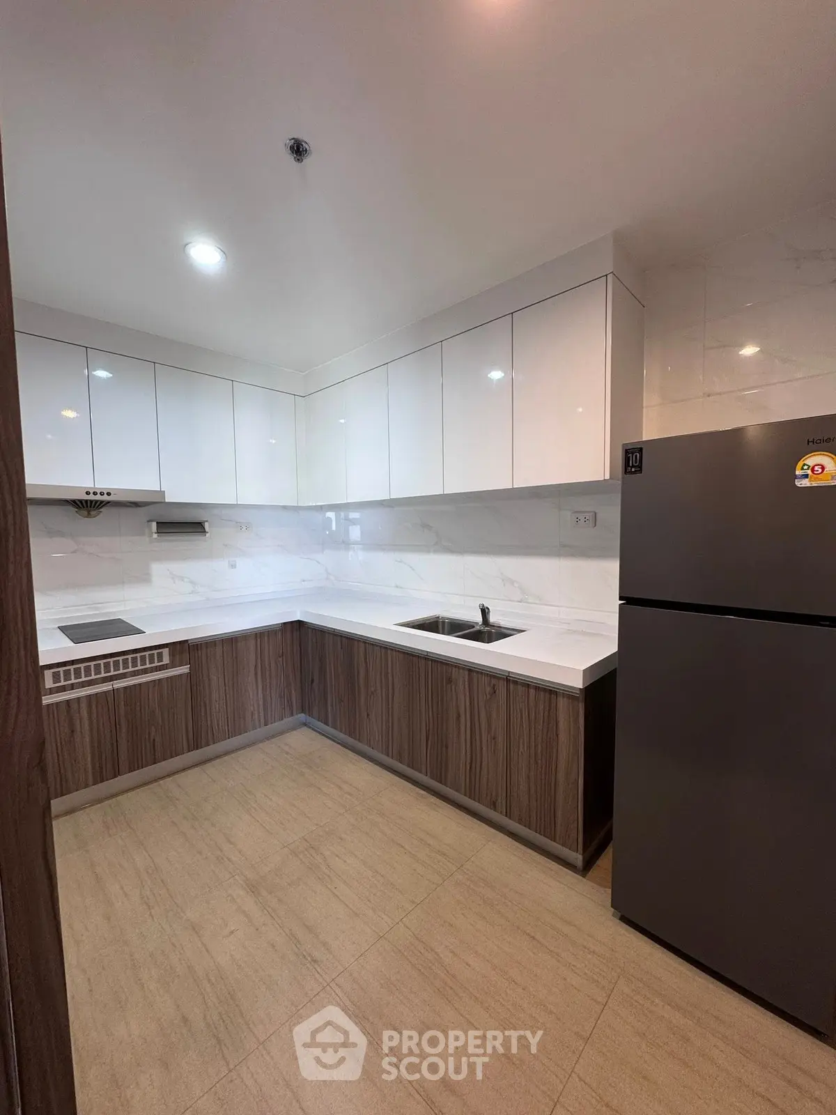 Modern kitchen with sleek cabinetry and stainless steel appliances in a contemporary apartment.