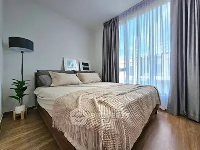 Cozy bedroom with large window and elegant decor, perfect for relaxation.