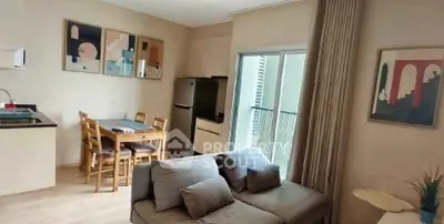 Modern living room with open kitchen and balcony access in stylish apartment.