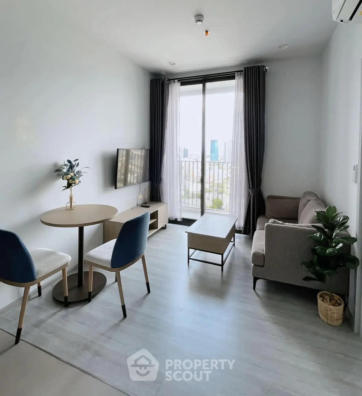 Modern living room with balcony view, stylish furniture, and natural light.