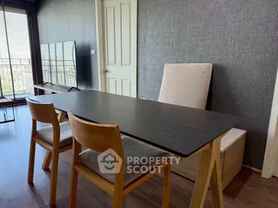 Modern living room with stylish furniture and large window offering natural light and city view.