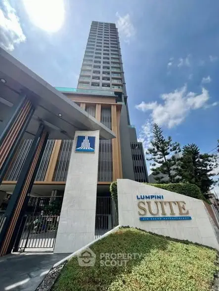 Modern high-rise building with elegant entrance and lush landscaping in Lumpini Suite.