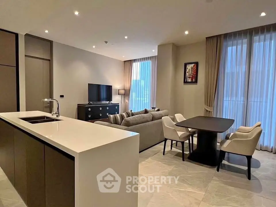 Modern open-plan living room with sleek kitchen island and elegant dining area.