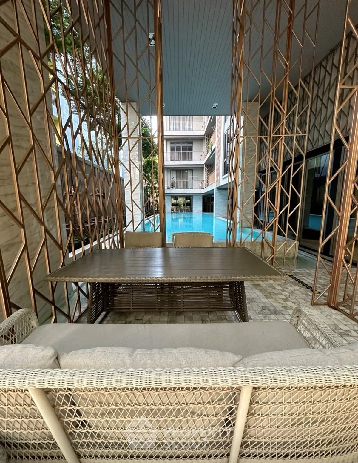 Luxurious outdoor seating area with pool view in modern apartment complex.