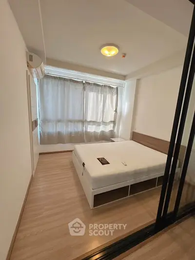Spacious bedroom with large window and modern design in a stylish apartment.