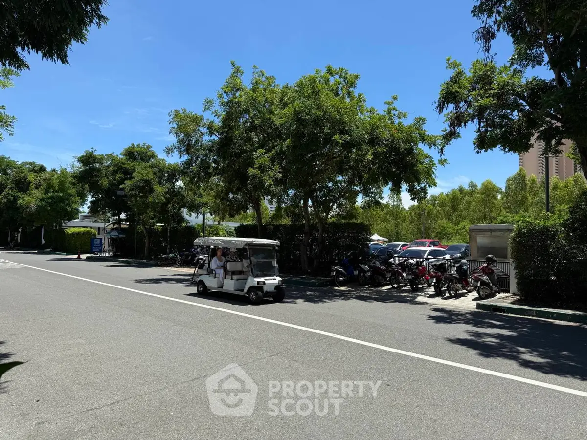 Spacious parking area with lush greenery and clear blue sky, ideal for residential or commercial properties.
