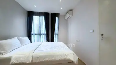 Modern minimalist bedroom with large windows and air conditioning in a stylish apartment.