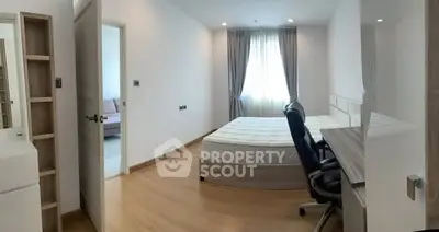 Spacious bedroom with natural light and modern furnishings in a stylish apartment.