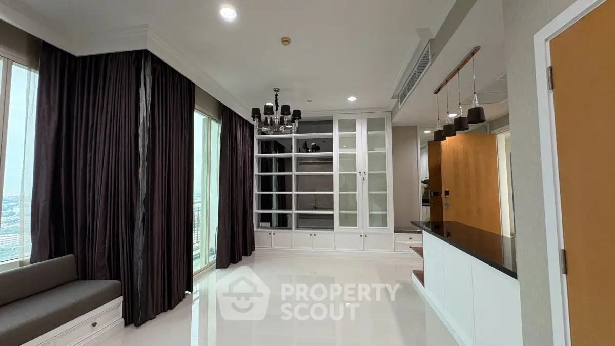 Spacious modern living room with large windows and elegant chandelier