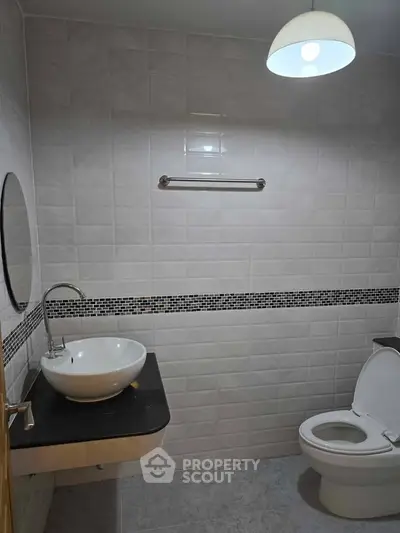 Modern bathroom with sleek white tiles and contemporary fixtures.