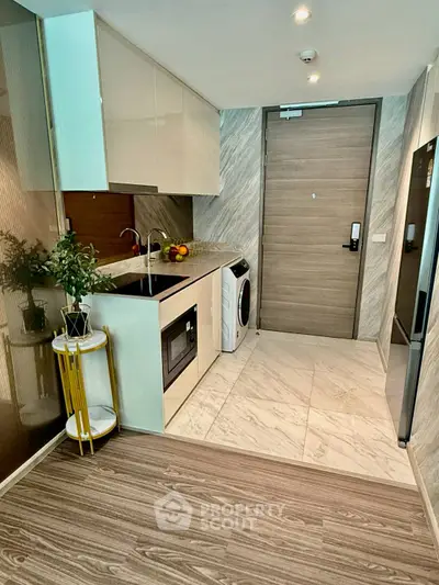 Modern kitchen with sleek appliances and stylish flooring in a contemporary apartment.