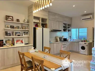 Modern kitchen with dining area, featuring wooden cabinets and washing machine