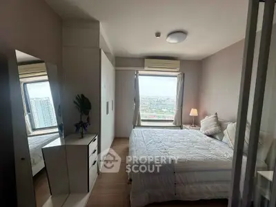 Cozy bedroom with city view, featuring a comfortable bed, modern wardrobe, and ample natural light.