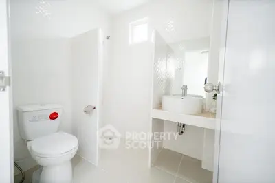 Modern minimalist bathroom with white fixtures and natural light