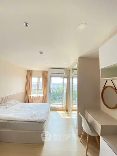 Bright and airy bedroom with balcony and scenic view, featuring modern furniture and ample natural light.