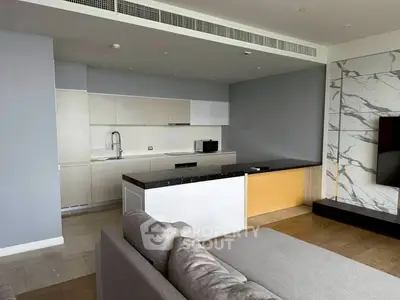 Modern open-layout kitchen with sleek cabinetry and spacious countertop in a stylish apartment.