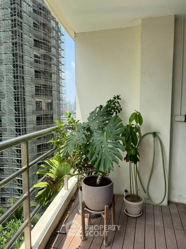 Spacious balcony with lush potted plants and city view, perfect for relaxation and enjoying the outdoors.