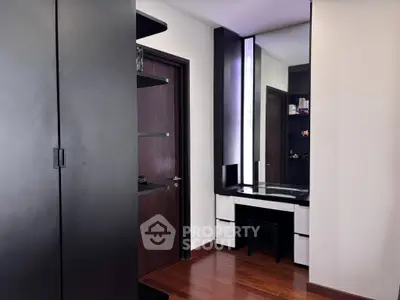Modern bedroom with sleek black wardrobe and stylish vanity area