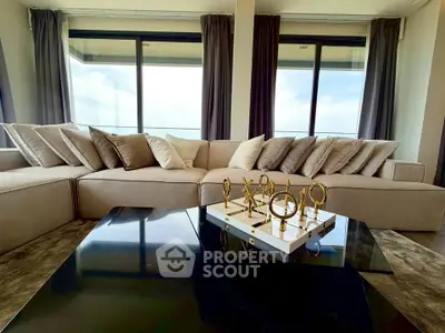 Luxurious living room with plush sofa and panoramic windows offering stunning views.