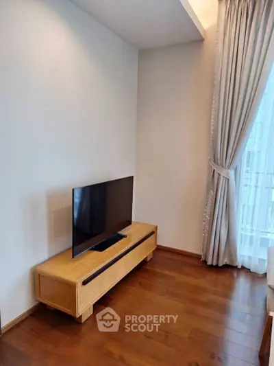 Modern living room with sleek TV stand and elegant curtains, perfect for cozy relaxation.