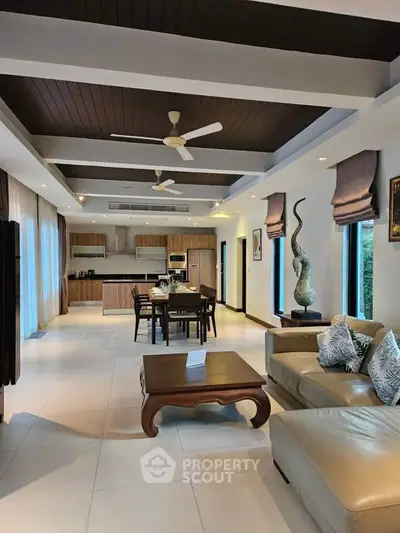 Luxurious open-plan living room with elegant decor and modern kitchen, perfect for entertaining.
