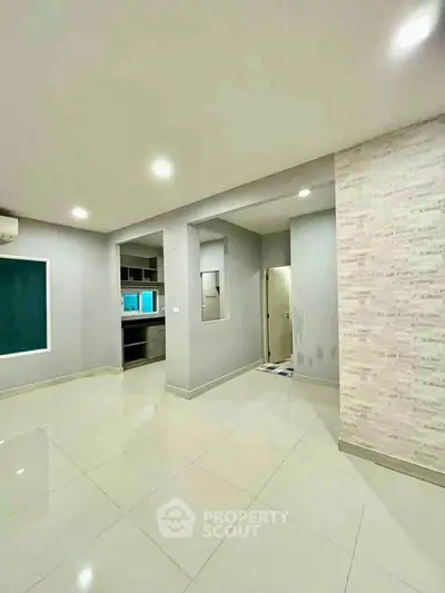 Spacious modern interior with sleek tile flooring and open layout kitchen.