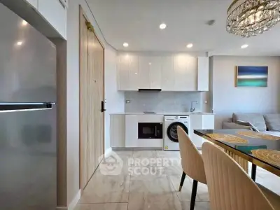 Modern open-plan kitchen and living area with sleek appliances and elegant dining setup.