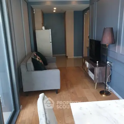 Modern living room with sleek furniture and wooden flooring in a stylish apartment.