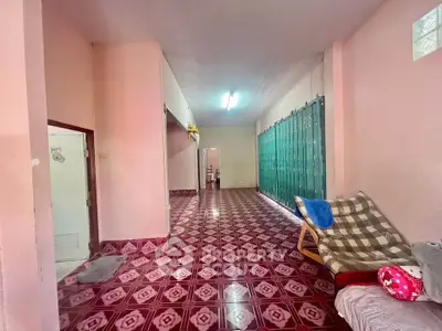 Spacious interior with unique patterned flooring and cozy seating area, ideal for creative living space.