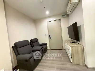 Cozy living room with modern recliners and wall-mounted TV, perfect for relaxation.