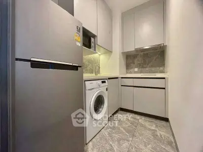 Modern compact kitchen with washing machine and sleek cabinetry