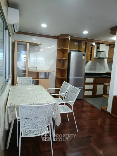 Spacious kitchen with dining area featuring modern appliances and elegant wooden cabinetry.