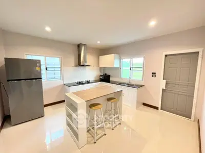 Modern kitchen with island, gas stove, and sleek appliances in a bright, open layout.