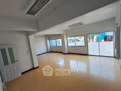 Spacious empty room with large windows and tiled floor, ideal for customization.