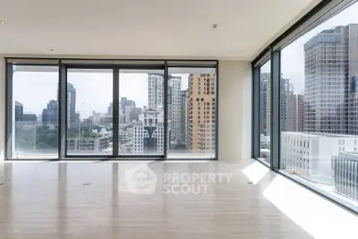Spacious modern living room with panoramic city views and floor-to-ceiling windows.